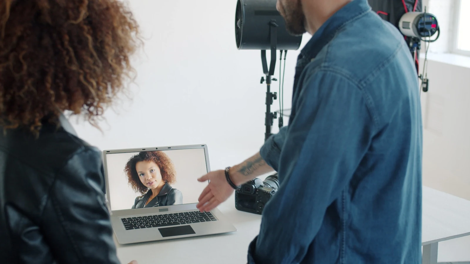 Photographer reviewing ad performance on laptop in studio