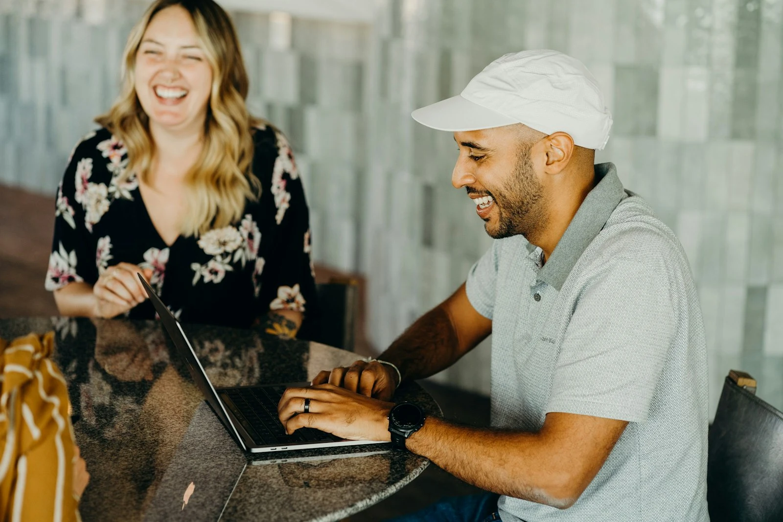 Happy photography client reviewing photos on a laptop with their photographer